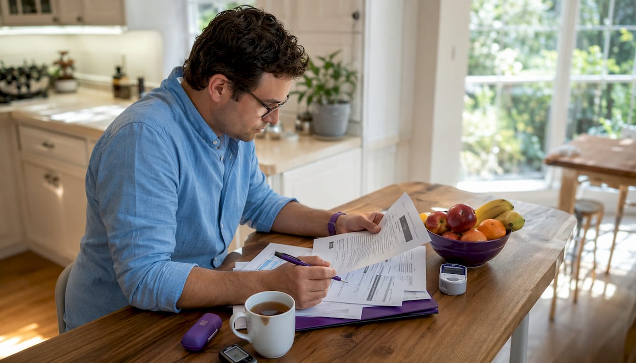 Person reviewing diabetic device insurance documents at home