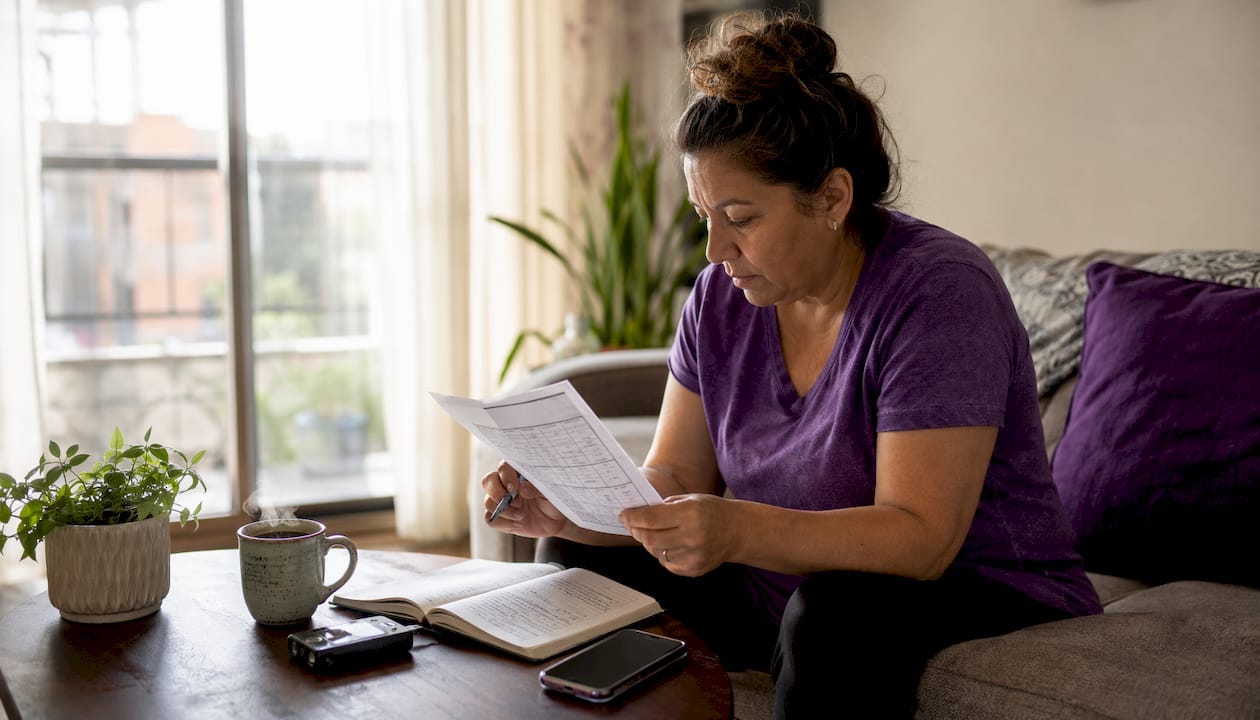 Woman reviewing diabetes device dose sheet at table