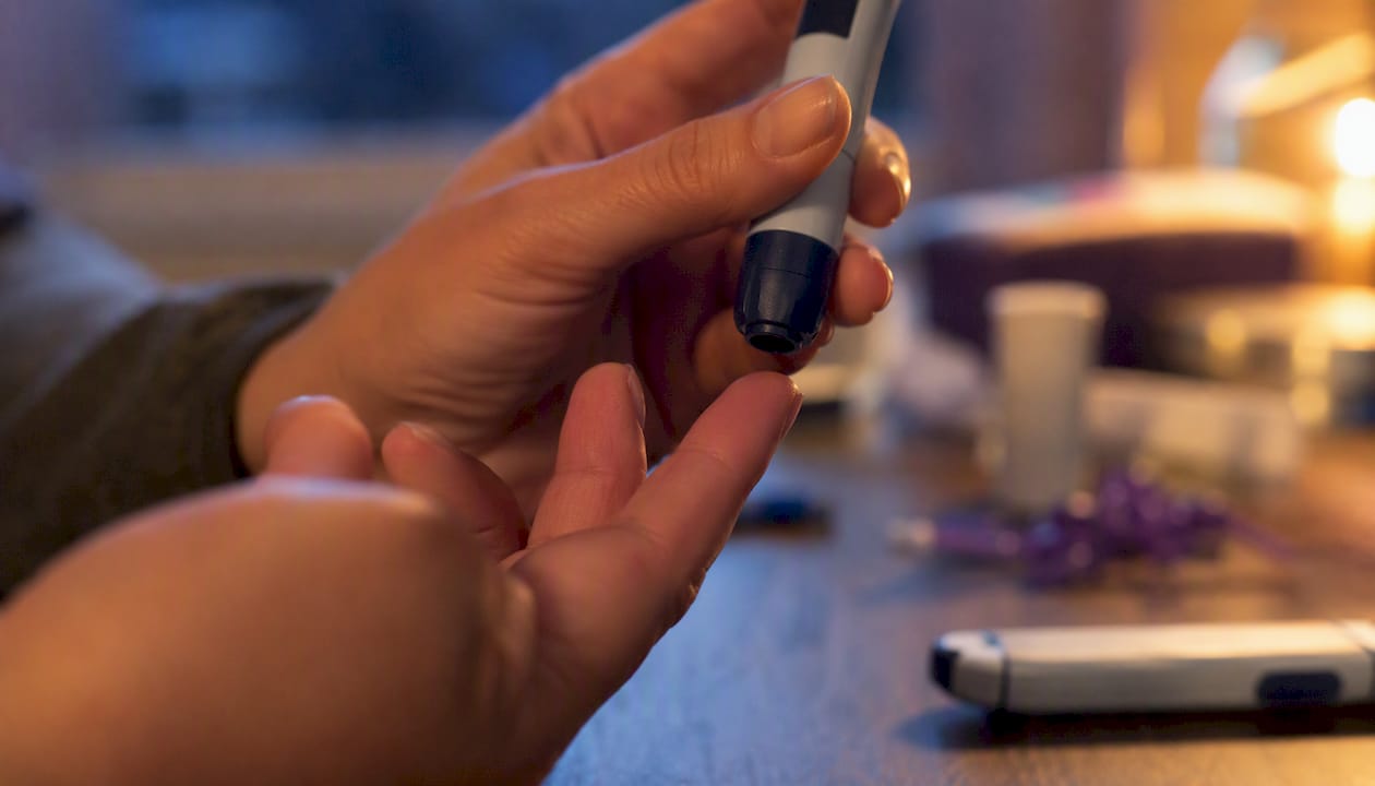 Hand holding lancet device preparing finger stick