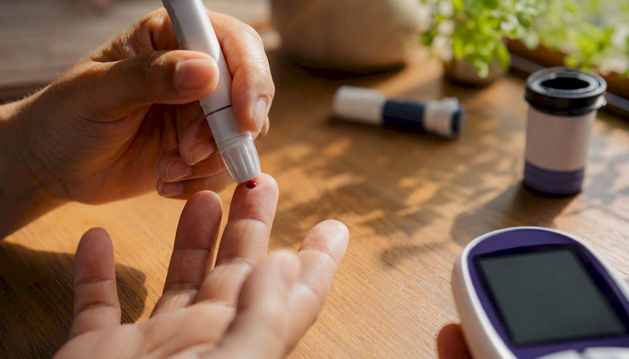 Hands drawing blood for glucose sensor calibration