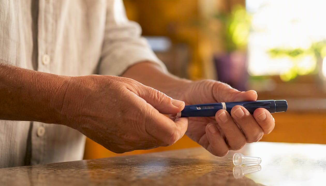 Hands preparing insulin injection with pen