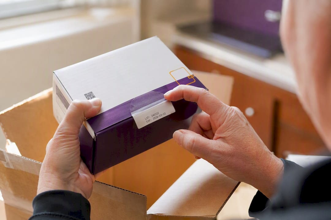 Hands inspecting seal and expiration on diabetic supplies box