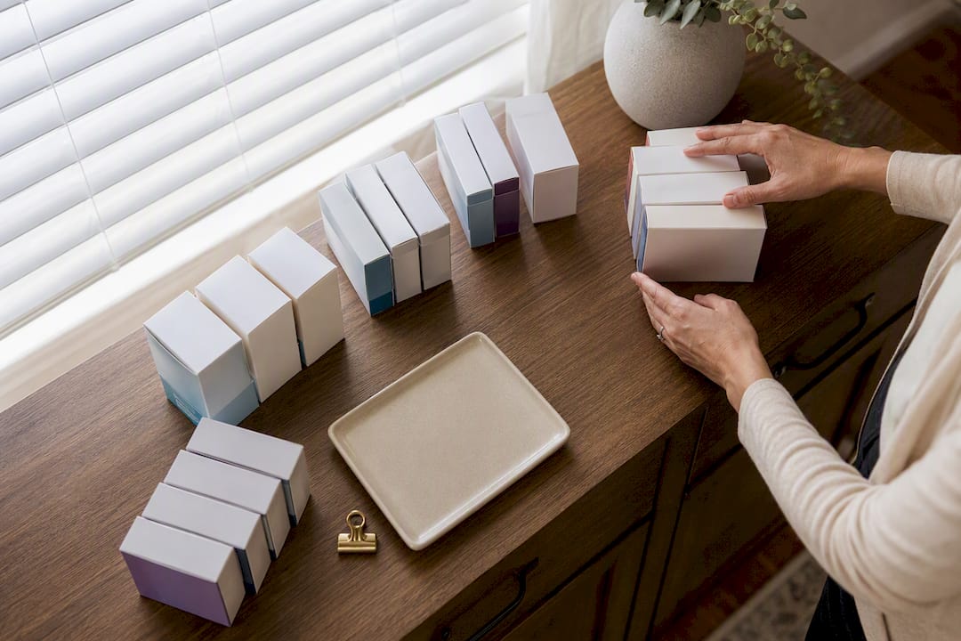 Hands grouping sealed supply cartons by date