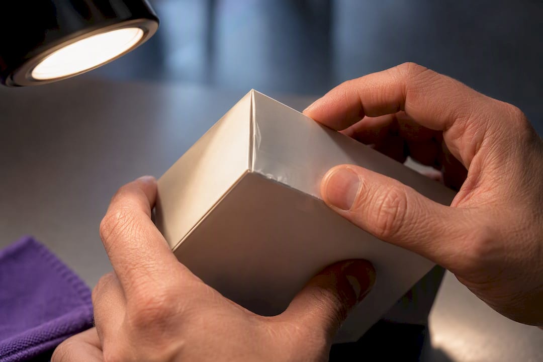 Hands examining a sealed carton seam
