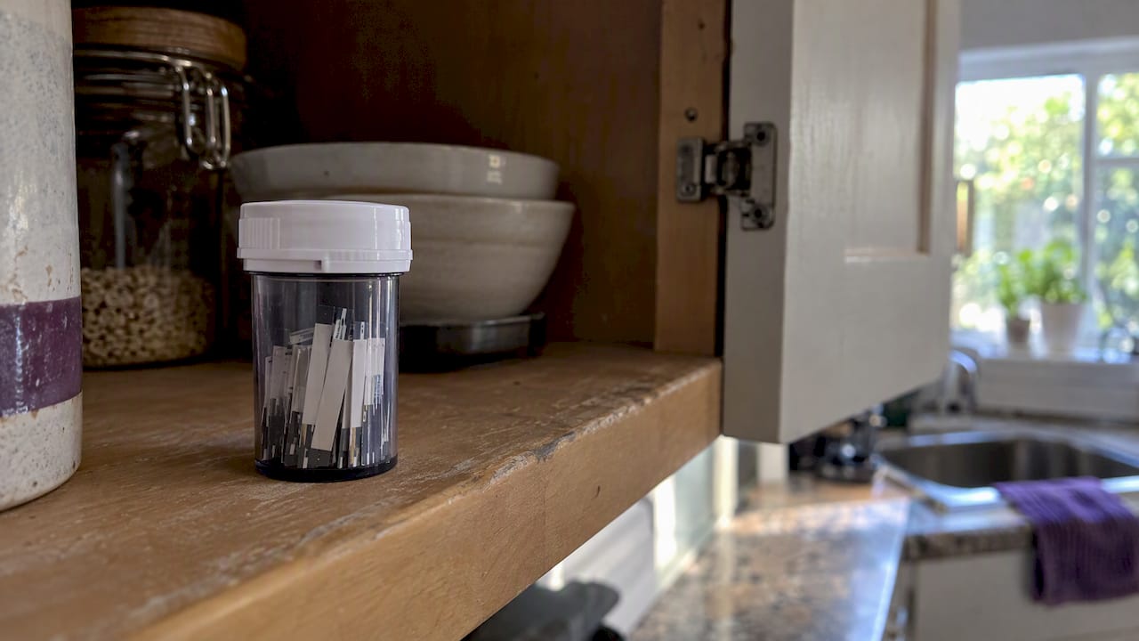 Capped glucose strip vial in cupboard