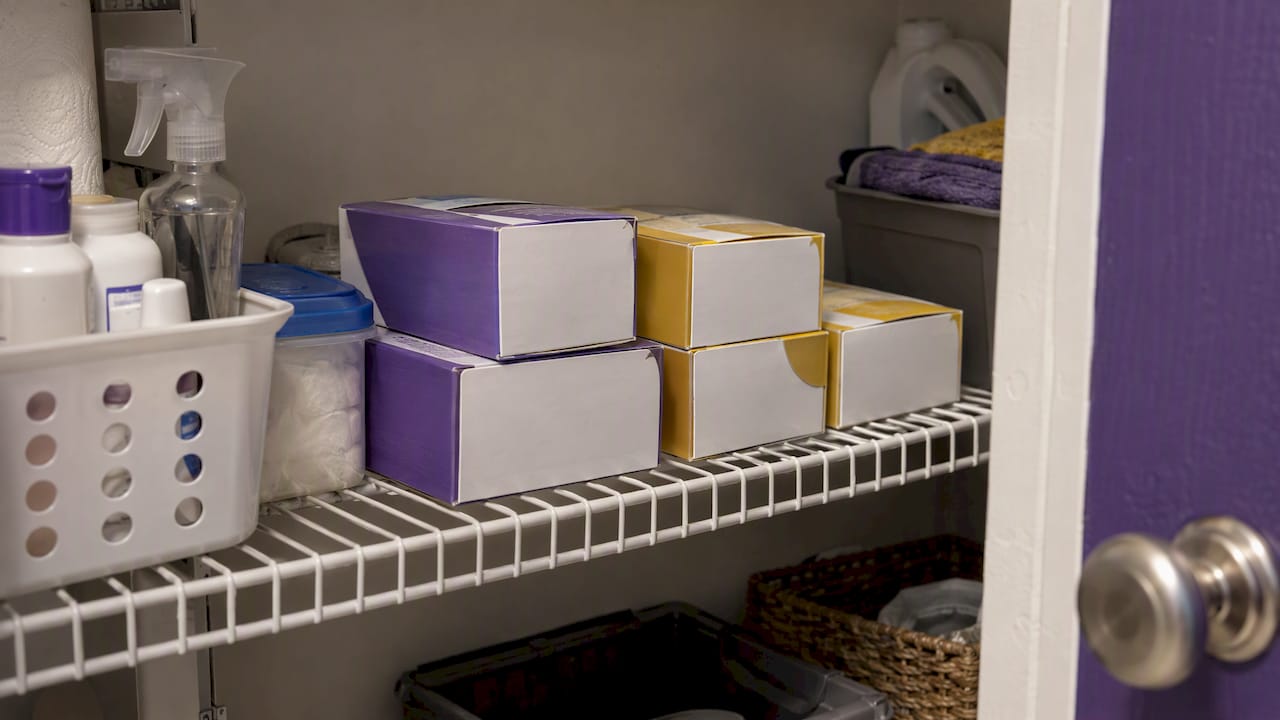 Sealed test-strip cartons on a closet shelf